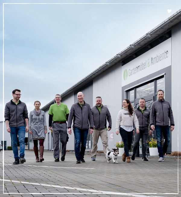 Unser tolles Team mit dem Bürohund Buddy vor dem Eingang